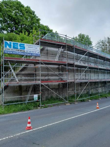 échafaudage en bord de route sur un mur de soutènement 